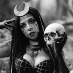 Gothic theme with woman holding a skull, set in a mystical forest.